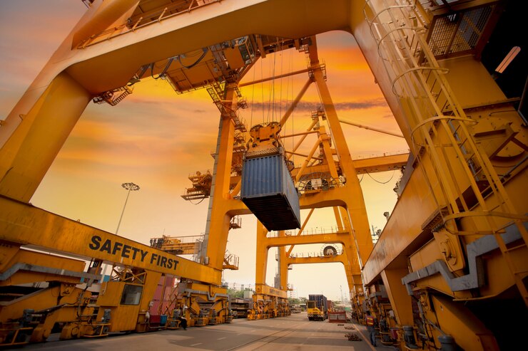 A massive yellow crane stands prominently amidst a bustling dock, symbolizing the efficient storage of goods reasons for using shipping containers for storage.