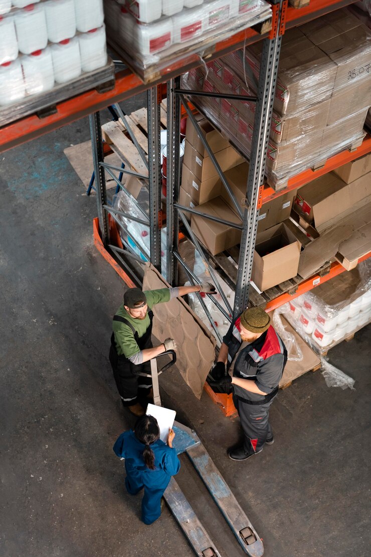 Three individuals in a well-organized warehouse, surrounded by neatly stacked boxes and shelves, engaged in shipping container maintenance.