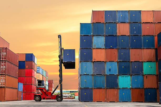 A forklift hoists a container amidst a stack of containers, highlighting the importance of shipping container maintenance.