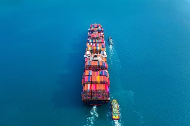 An aerial view of a container ship sailing in the vast ocean, symbolizing the transformative impact of shipping containers on global trade.


