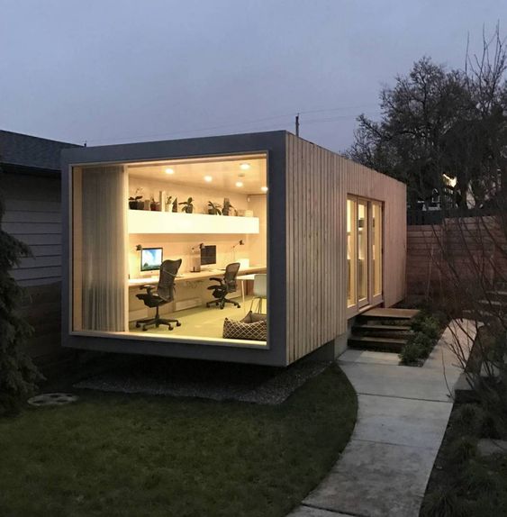 A modern office with a desk and a window, featuring a fit air system in a shipping container.
