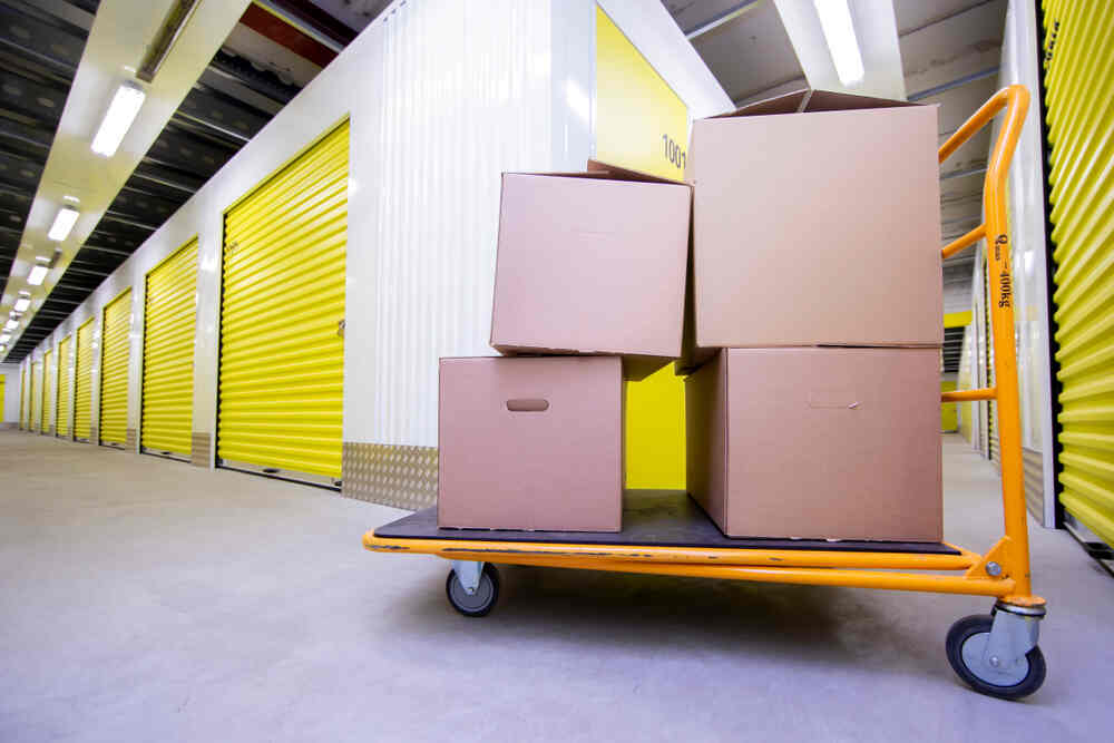A storage facility with a cart filled with boxes, showcasing the convenience of renting storage containers.